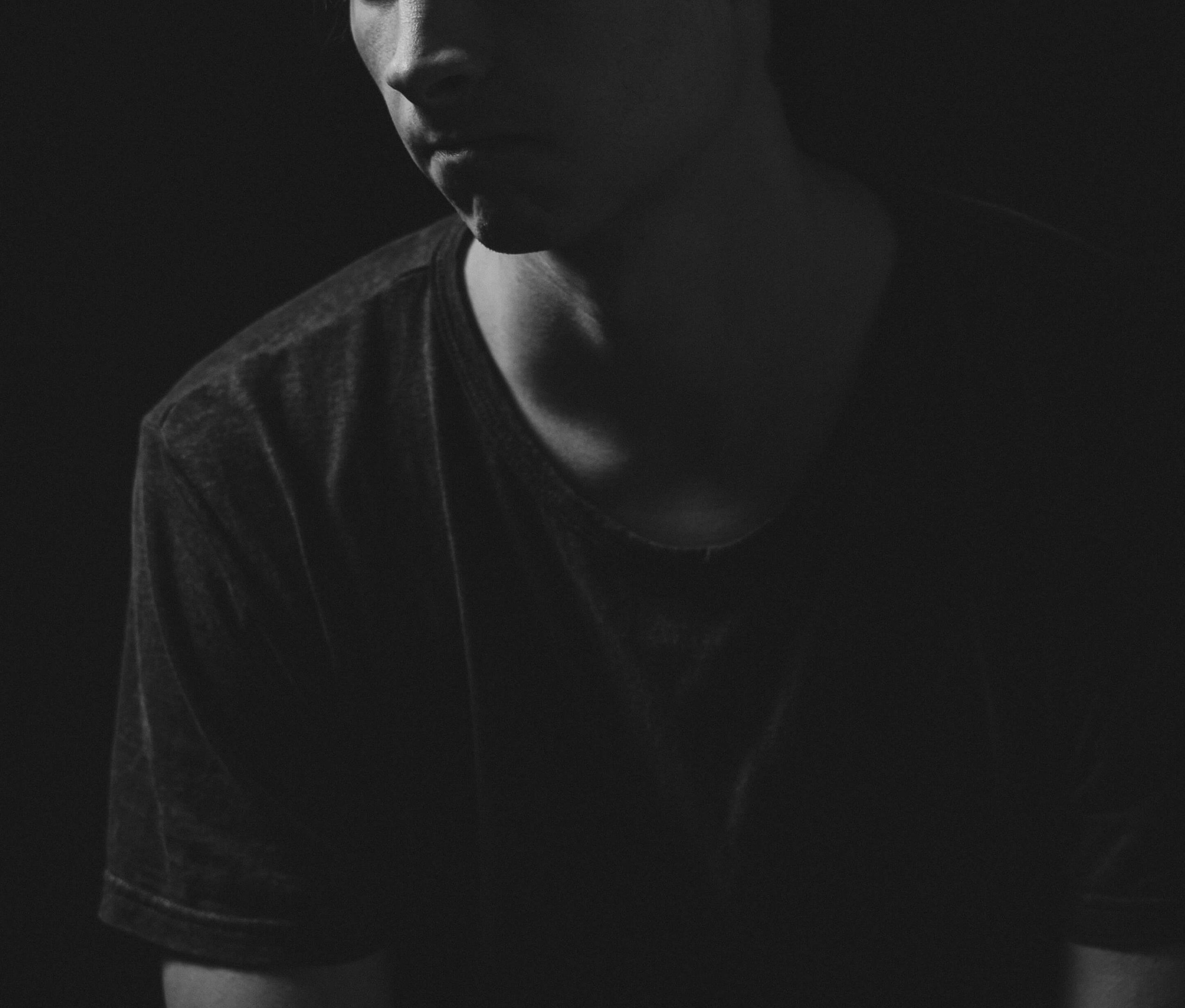 Black and white image of a young man in thought. Work with a skilled depression therapist to help you manage your depression symptoms. Find support in coping with depression counseling in Englewood, CO.