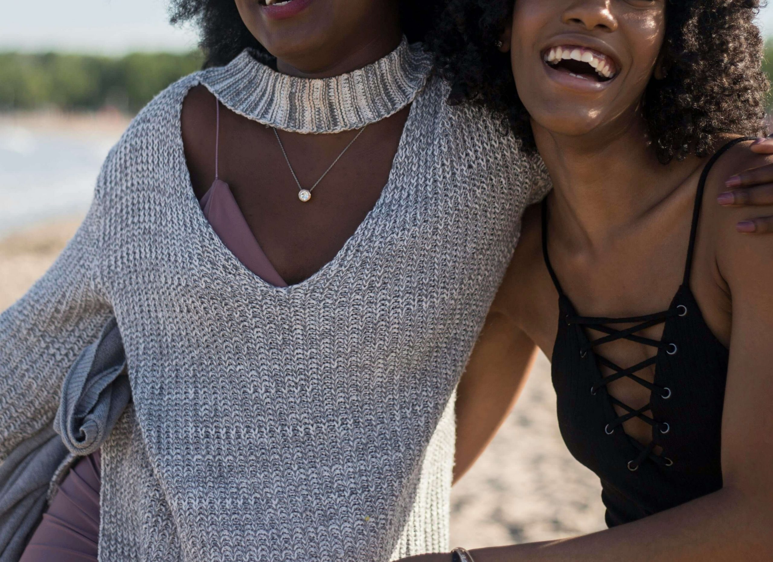 Image of two smiling African American women hugging and walking on a beach. Learn to connect with your family with the help of family therapy in Englewood, CO. Work with a skilled family therapist to overcome your conflict.