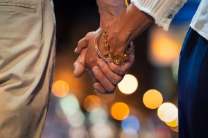 A close up of a couple holding hands against blurry city lights at night. This could represent how couples therapy in Greenwood Village, CO can offer support with cultivating bonds. Learn more about relationship counseling in Englewood, CO and how couples therapy in Englewood, CO can help today. 