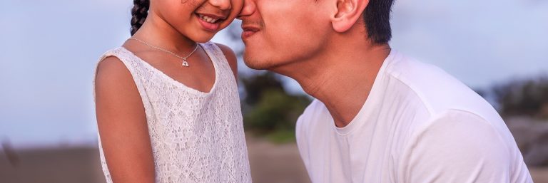 A close up of a father kissing the cheek of their daughter. This could represent a gentle parenting style. Learn more from a family therapist in Englewood, CO or search for a relationship therapist in Englewood, CO.